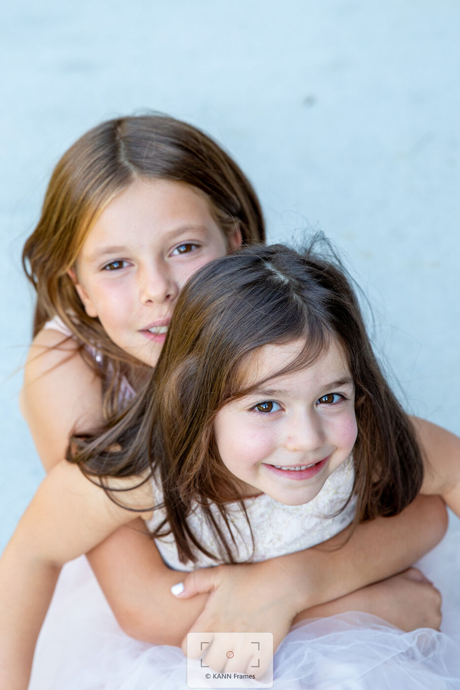 Two sisters smiling together in a studio portrait